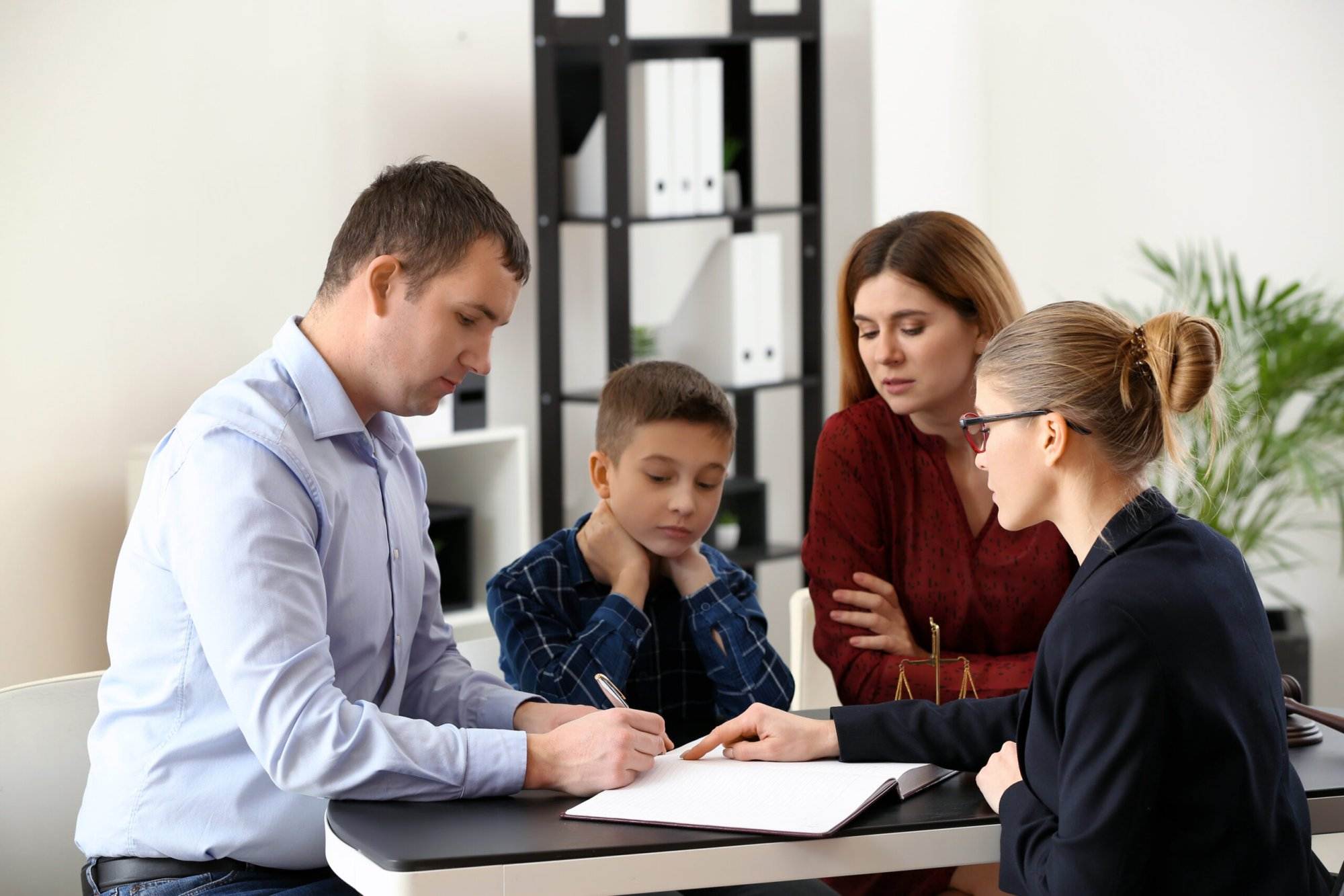 Family consulting with lawyer at modern office table.