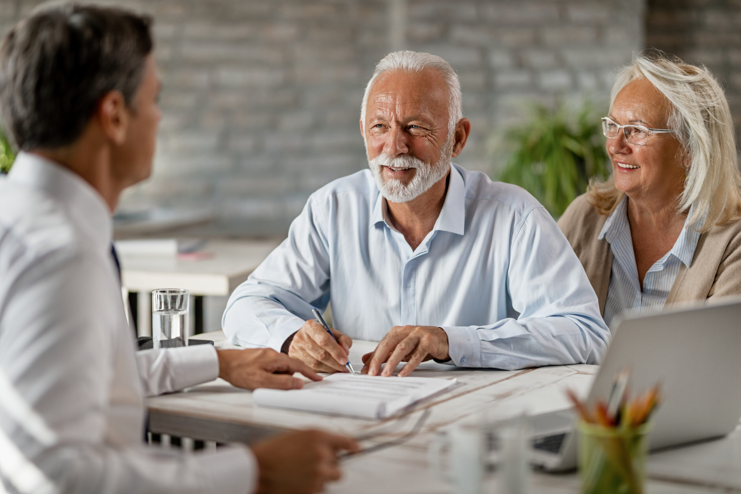 An elderly couple consulting with a lawyer, discussing important legal documents.