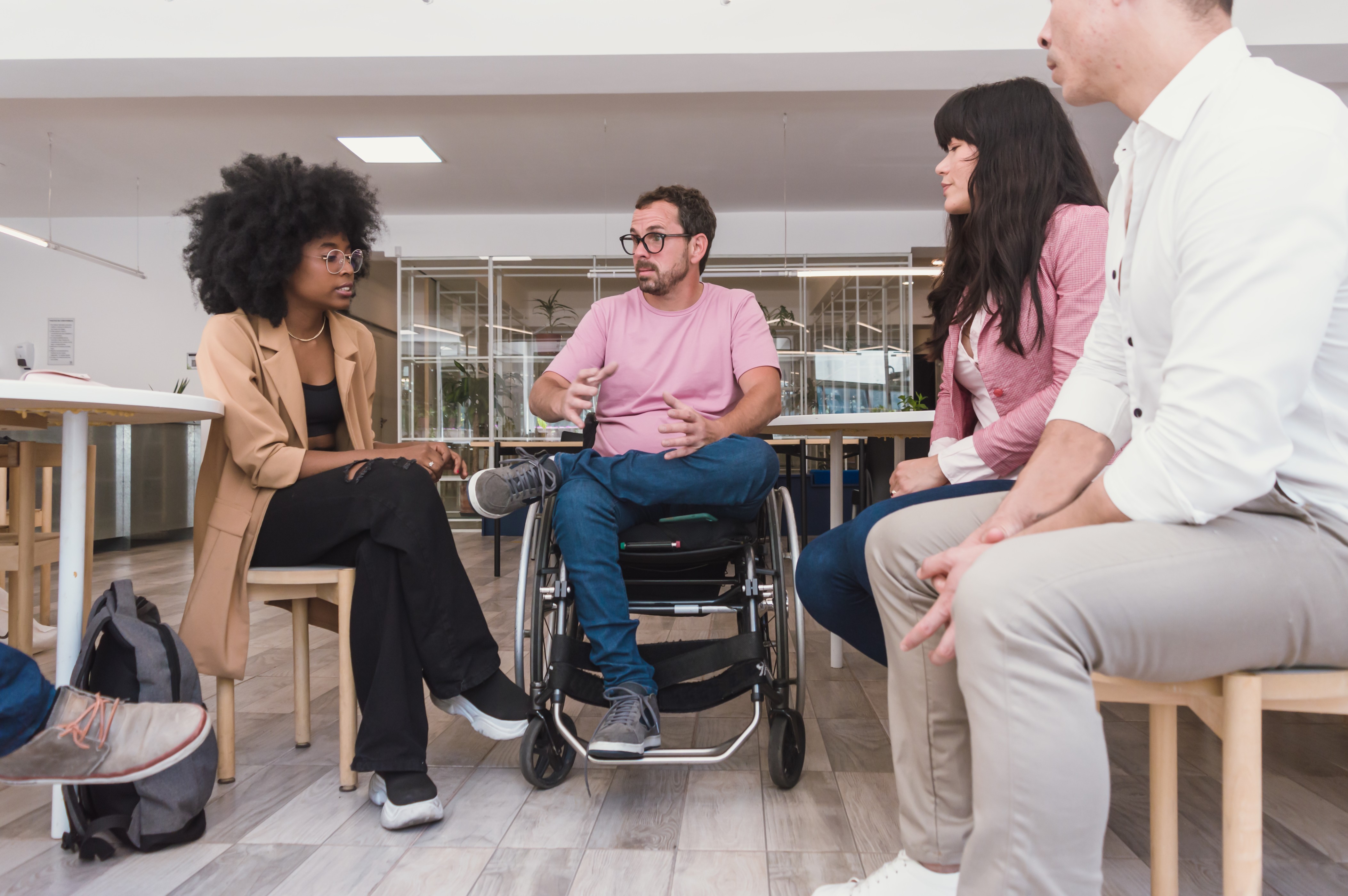 Man in wheelchair leading office group discussion