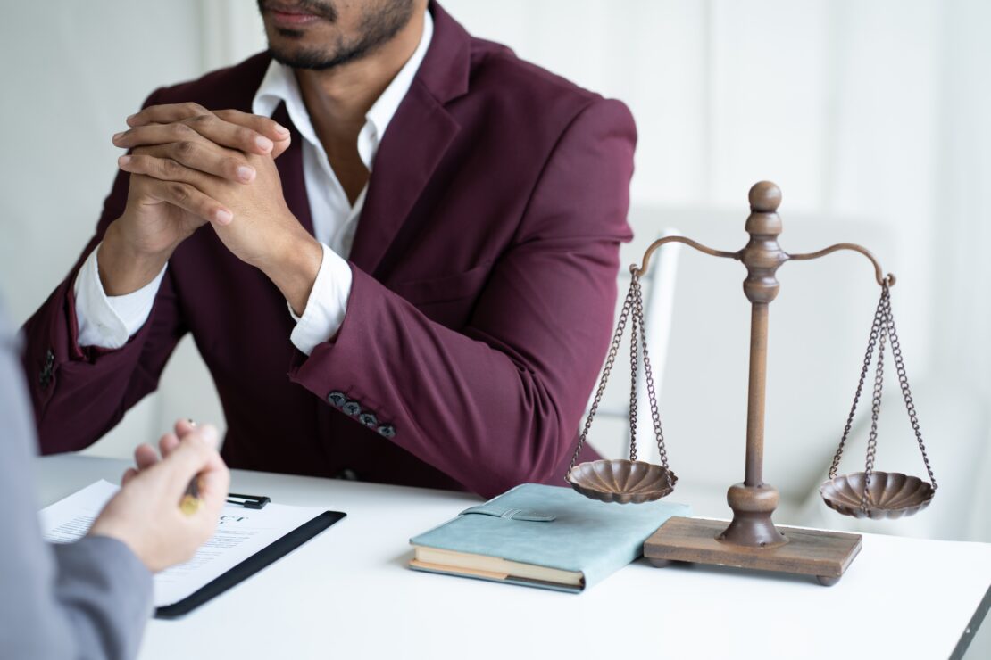 Man consulting lawyer with justice scales