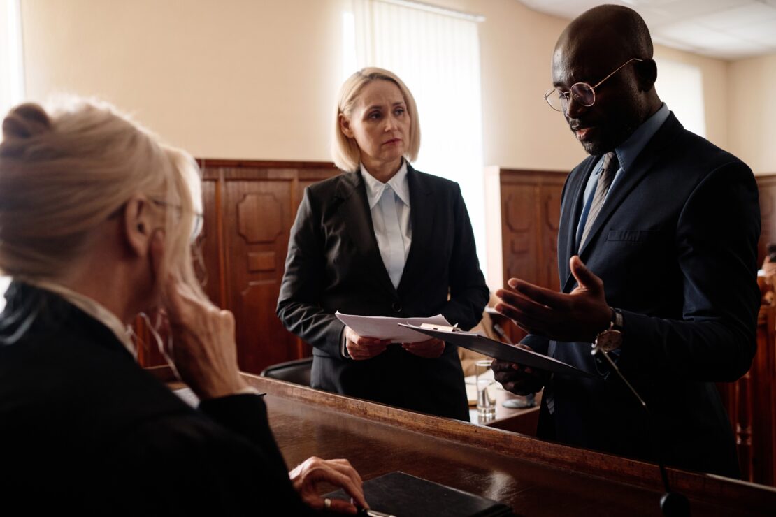 lawyers consulting documents in courtroom
