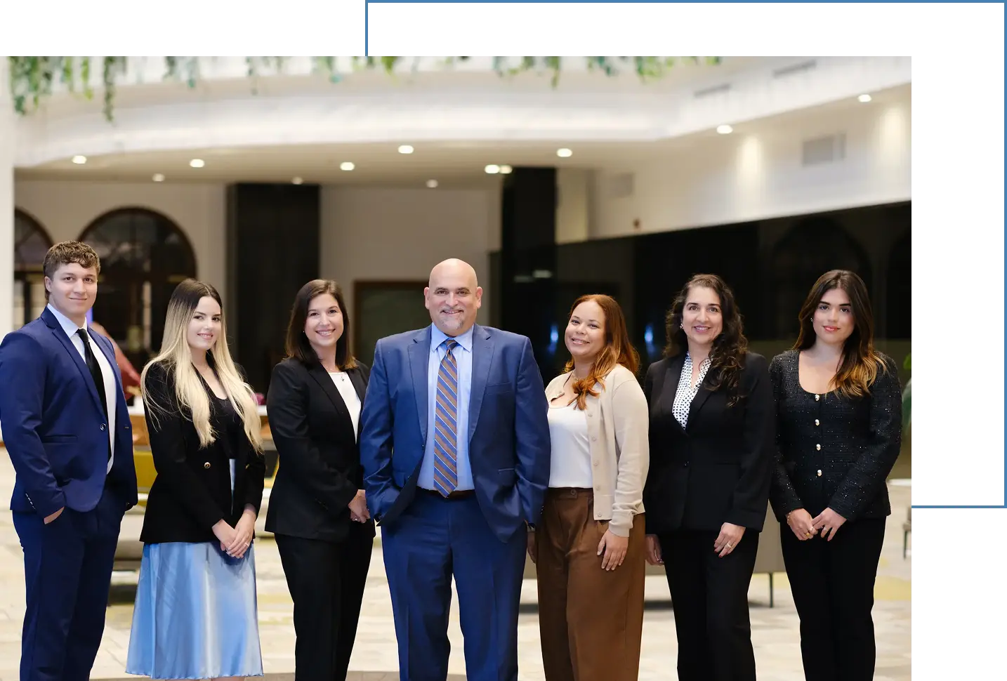 business team standing in office lobby smiling