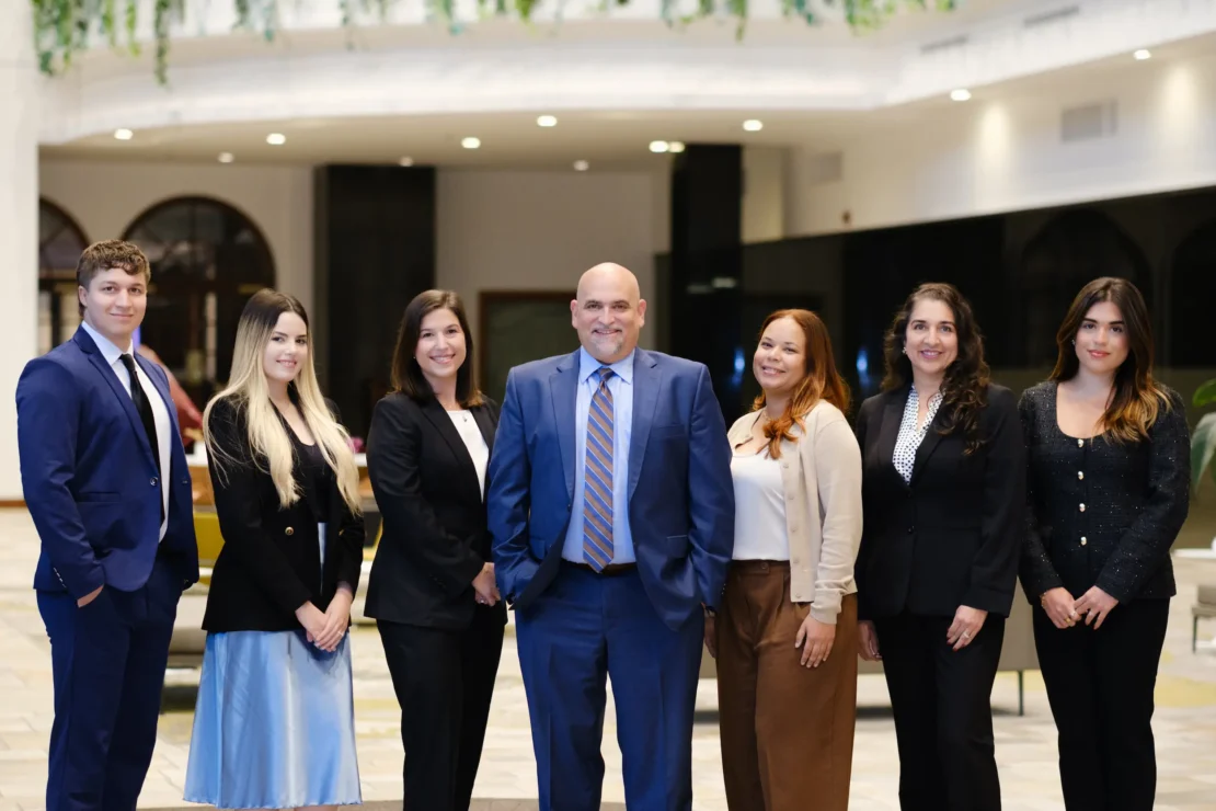 Business team standing in office lobby smiling