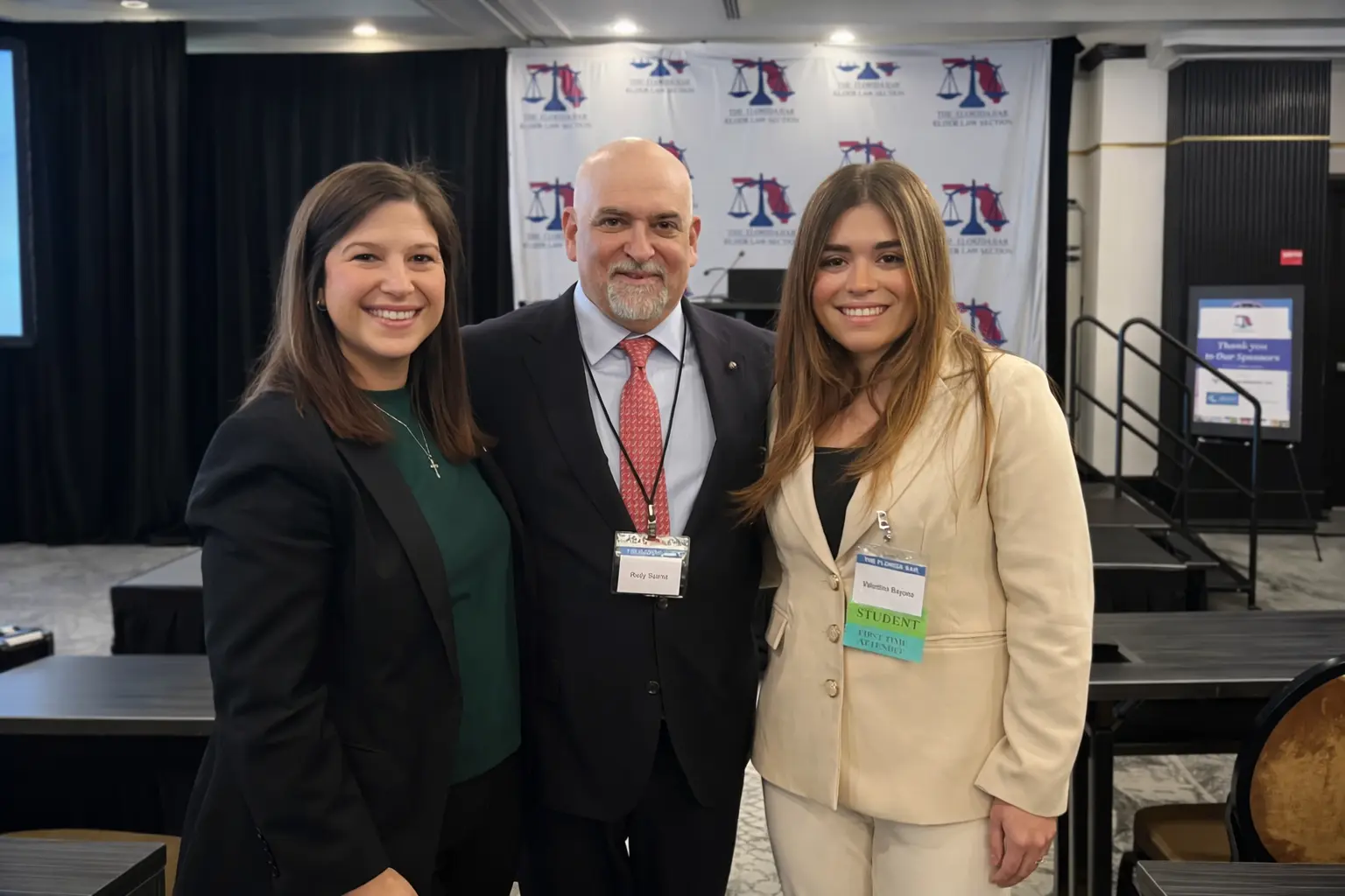 Three professionals smiling at legal conference