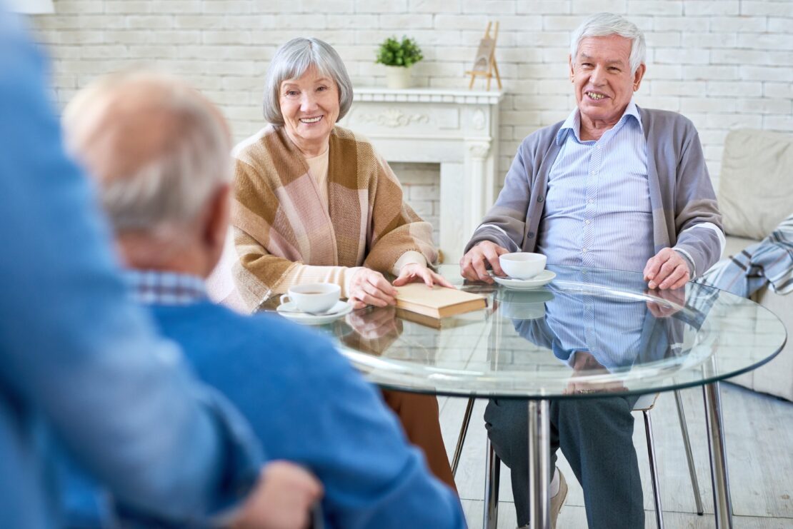Elderly couple drinking tea at glass table