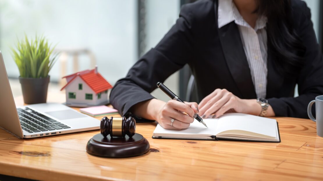 Real estate lawyer writing notes at desk