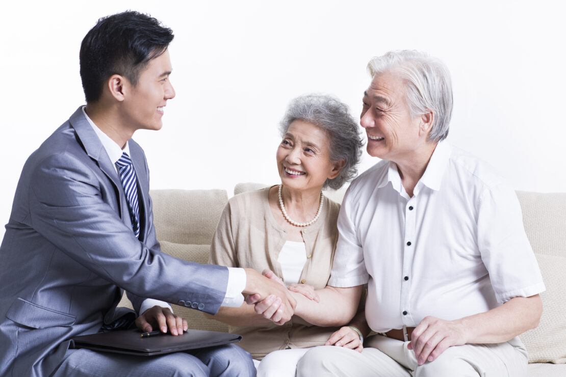Young man shaking hands with elderly couple