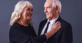 Elderly couple smiling and embracing affectionately
