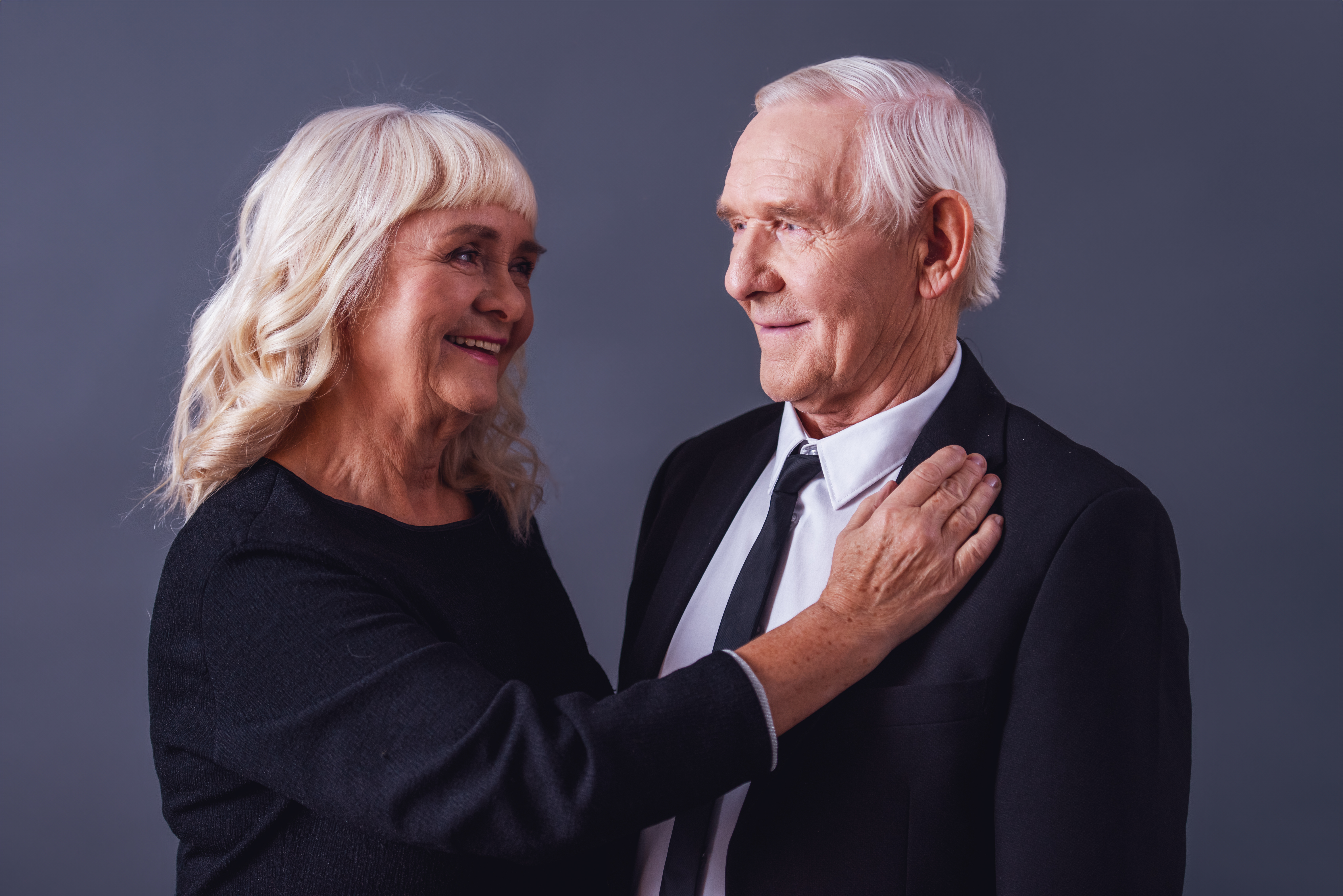 Elderly couple smiling and embracing affectionately